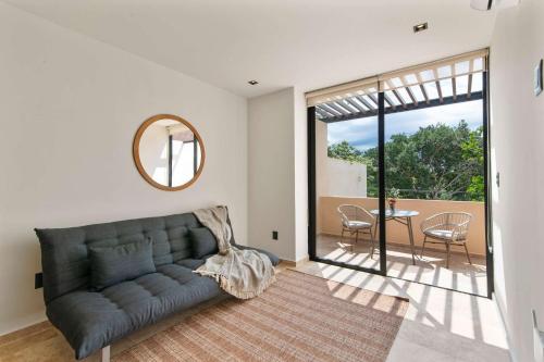 a living room with a couch and a table at Stylish 1BR Condo with Private Pool & Balcony in Tulum