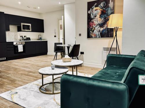 Una sala de estar con un sofá y dos mesas. en Royal Stay-Leeds City centre Apartment, en Central Station