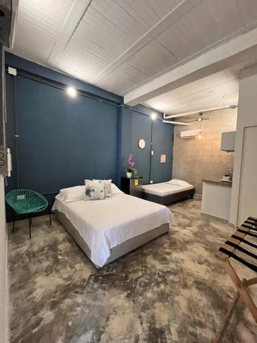 a bedroom with a large bed and a blue wall at Calma Hospedaje in Turbaco