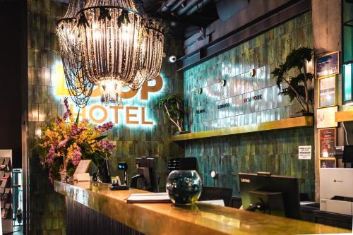 a restaurant with a chandelier and a hotel sign at Loop Hotel Vilnius in Vilnius