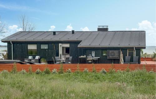 a black house with a fence in front of it at 3 Bedroom Amazing Home In Sjølund in Binderup Strand