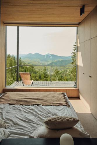 a bedroom with a bed and a large window at Висота890 in Volosyanka