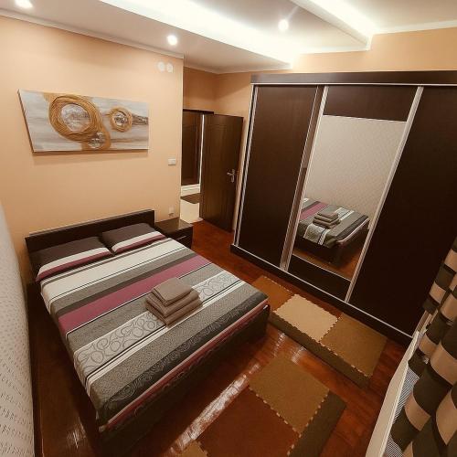 a bedroom with a bed and a large mirror at Niš Apartment in Niš