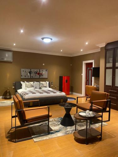 a bedroom with a bed and a living room at Stone Guesthouse in Gaborone