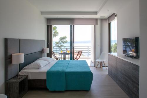 um quarto com uma cama, uma televisão e uma varanda em Soho Apartments Brela em Brela