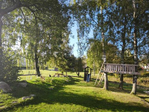 a park with a wooden bench and a playground at Kořenov 10 chalupa na horách in Kořenov