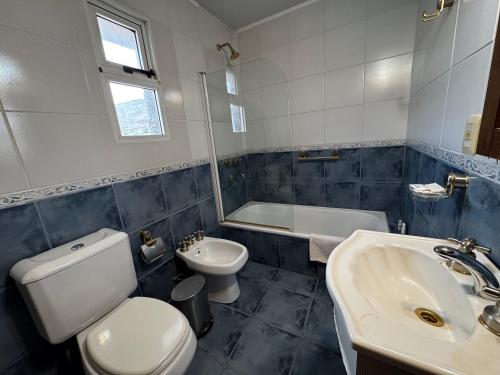 un bagno con un water, un lavandino e una vasca di Departamento familiar! excelente ubicación a El Calafate