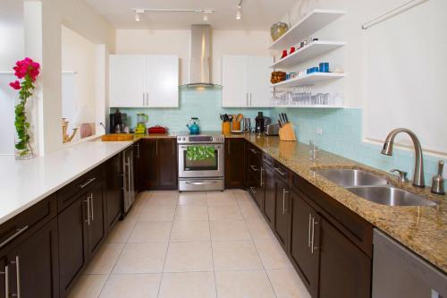 cocina con armarios marrones y fregadero en Babylon Reef, en North Side