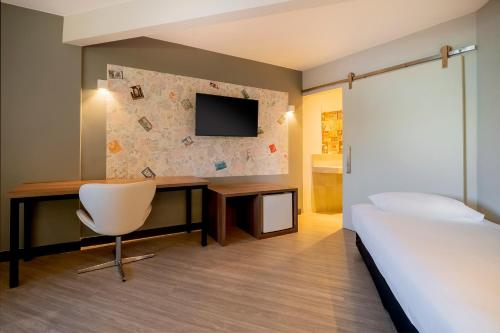 a bedroom with a bed and a desk and a tv at ibis Styles Sorocaba Santa Rosalia in Sorocaba