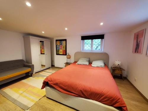 a bedroom with a large bed and a couch at Appartement cozy dans maison portes de Strasbourg in Lingolsheim
