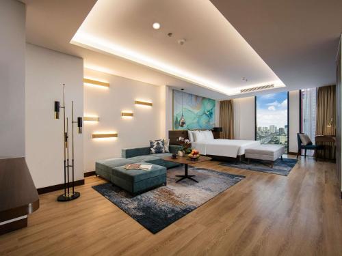ハノイにあるMövenpick Living West Hanoiのソファとテーブルのあるリビングルーム