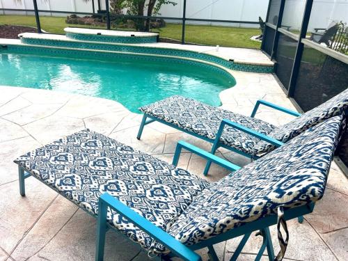 un paio di sedie sedute accanto a una piscina di Heated Pool, Hot Tub, Fire Pit, Games, RV and Boat Parking a Port Charlotte