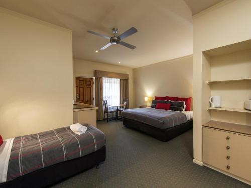a hotel room with two beds and a ceiling fan at Breakfree Port Pirie in Port Pirie