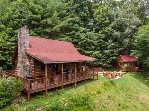 a log cabin with a red roof and a fireplace at Moonlight Lodge in Fleetwood