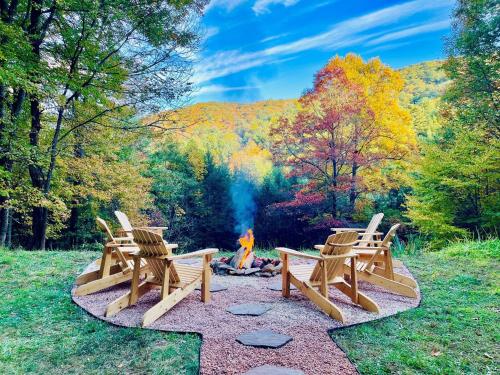 a group of chairs sitting around a fire in the woods at Moonlight Lodge in Fleetwood