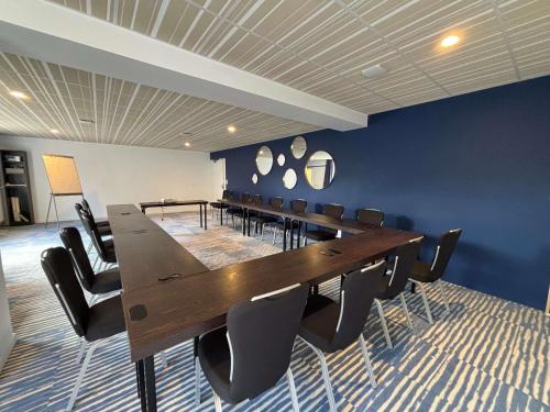 a conference room with a long wooden table and chairs at ibis Styles Morlaix in Morlaix