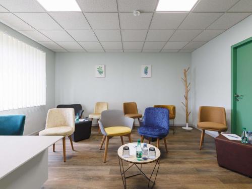 a waiting room with colorful chairs and a table at Mercure Aix-les-Bains Domaine de Marlioz Hôtel & Spa in Aix-les-Bains