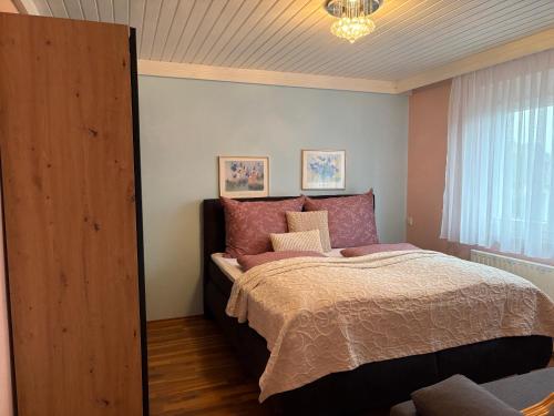 una camera da letto con un letto e un lampadario di WM GEDER Ferienwohnungen Villa Tanja a Lebring