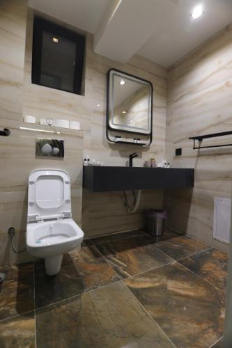 a bathroom with a toilet and a tv on the wall at Aqua Raj ND in Novi Pazar