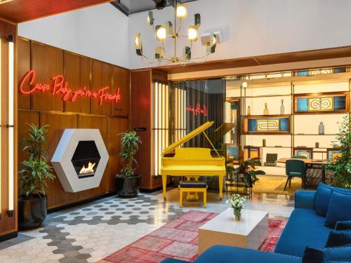 a lobby with a yellow piano in a room at Pullman Budapest in Budapest