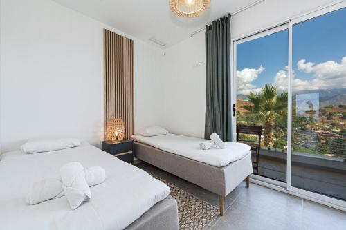 a bedroom with two beds and a large window at Bayview Hills Suite by Casasol in Torrox