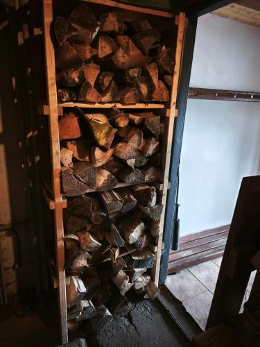 a pile of fire wood in a wooden rack at Kořenov 10 chalupa na horách in Kořenov