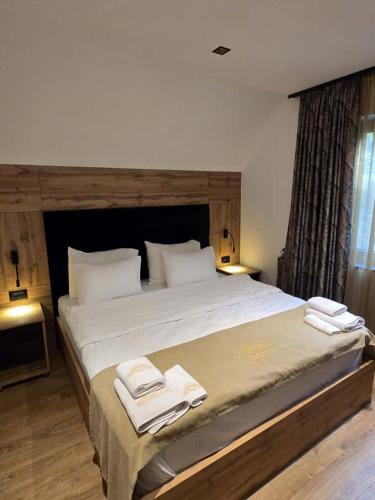 a bedroom with a large bed with towels on it at Aqua Raj ND in Novi Pazar
