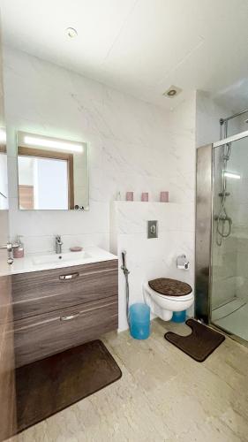 a bathroom with a toilet and a sink and a shower at Serenity - Appart Piscine - 4-5p in Agadir