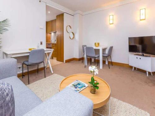 una sala de estar con un sofá y una mesa en Cozy Central Apt with Pool & Gym by Zodiak Stays, en Auckland