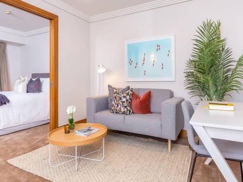 a living room with a couch and a table at Cozy Central Apt with Pool & Gym by Zodiak Stays in Auckland