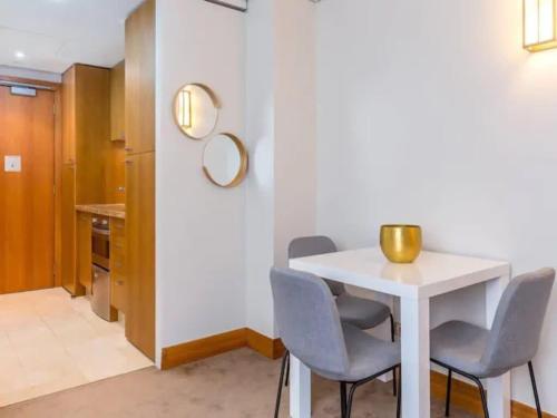 a dining room with a white table and chairs at Cozy Central Apt with Pool & Gym by Zodiak Stays in Auckland