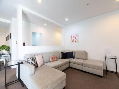 a living room with a couch and a table at Spacious Home with Balcony Parking Zodiak Stays in Auckland