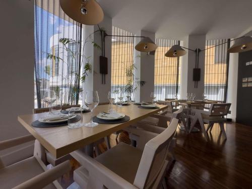 a dining room with a table and chairs and windows at The Classic Hotel Nicosia - Handwritten Collection in Nicosia