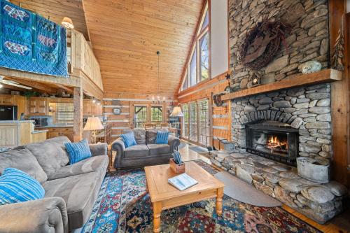 a living room with a stone fireplace in a cabin at Mountain Masterpeace in Banner Elk