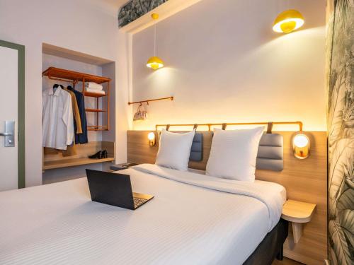 a hotel room with a bed with a laptop on it at Hotel Siru Brussels in Brussels