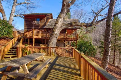 a tree house with a bench on a deck at Fox's Lair in Sugar Grove