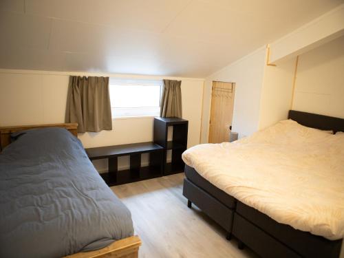 a bedroom with two beds and a window at Tiny Home in Oirschot next to forest in Haghorst