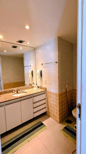 a bathroom with two sinks and a mirror and a toilet at Unidade Autonoma 609 em Villa Del Sol in Rio de Janeiro