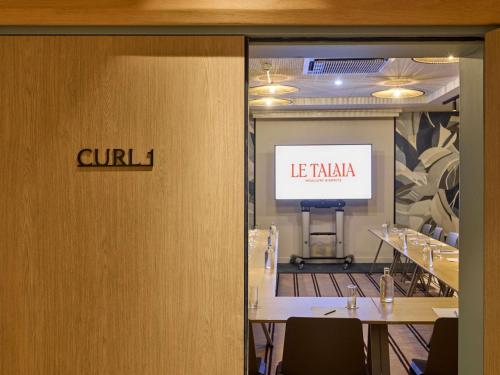 a conference room with a table and a sign on the door at Le Talaia Hôtel & Spa Biarritz - MGallery Collection in Biarritz
