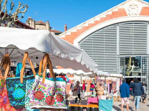 a market with bags on display in front of a building at Le Talaia Hôtel & Spa Biarritz - MGallery Collection in Biarritz
