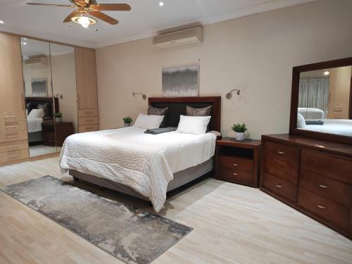 a bedroom with a bed and a large mirror at Executive Suite in Vanderbijlpark