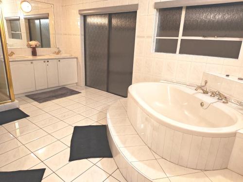 Un baño blanco con bañera y lavabo. en Executive Suite, en Vanderbijlpark