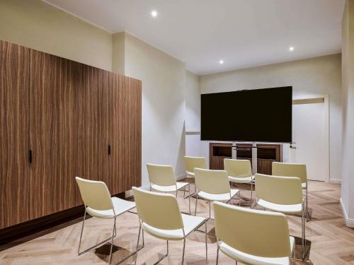 a conference room with chairs and a flat screen tv at Hotel Giacomo Morra Alba - Handwritten Collection in Alba