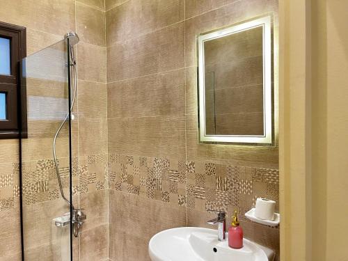 a bathroom with a sink and a shower with a mirror at Snow light 2BDR , Madinaty in Madinaty