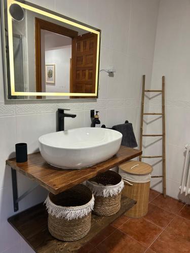 a bathroom with a large white sink and a mirror at La villa de Leo y Lola in Frómista