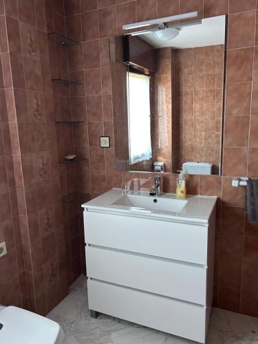 a bathroom with a white sink and a mirror at Sella in Arriondas
