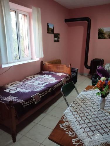 Un dormitorio con una cama y una ventana y una mesa. en Vogli APARTMENTS ERSEKE, en Ersekë