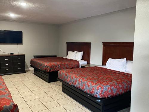 a hotel room with two beds and a flat screen tv at PASCAGOULA EXTENDED STAY in Pascagoula