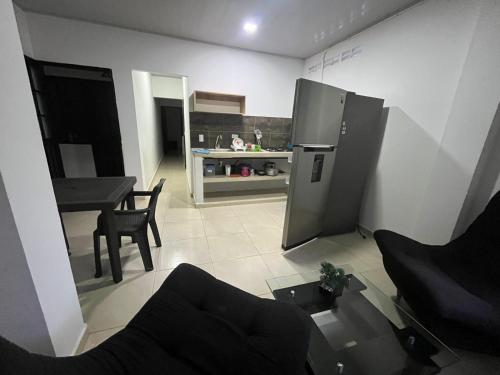 a kitchen with a table and a refrigerator in a room at EL EDÉN in Puerto Triunfo