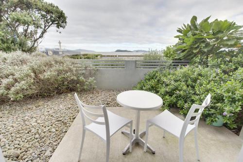 a table and two chairs and a white table and chairs at BKs Premier Motel Esplanade in Lower Hutt